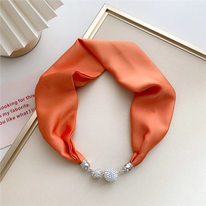 Elegant orange satin scarf necklace with crystal magnetic buckle on decorative tray