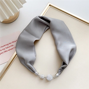 Detailed view of gray satin scarf with elegant sparkling rhinestone magnetic clasp closure