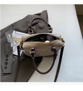 Close-up of contrast color Boston bag showing large capacity interior and metal hardware