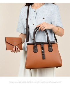 Detail of tan pebble leather tote bag set with matching envelope pouch and top handles