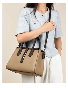 Detail of khaki pebbled leather tote bag showing gunmetal hardware and contrasting straps