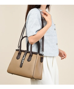 Detail of khaki leather tote bag with dark brown straps and polished silver metal clasp