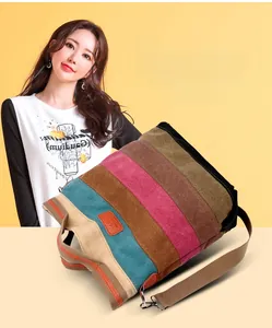 Detail of colorful striped canvas tote bag with brown straps and orange leather patch