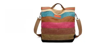Detail of colorful striped canvas tote bag with orange leather patch and long shoulder strap