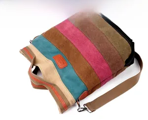 Detail of colorful striped canvas tote bag showing stitching and brown leather label