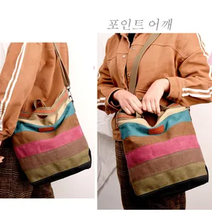 Detail view of multi-color striped canvas tote bag with adjustable olive green strap