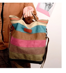 Detail of colorful striped canvas tote bag with leather logo patch and dual carry options