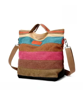 Detail of colorful striped canvas tote bag with leather strap and adjustable shoulder belt