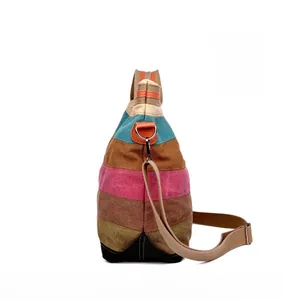 Side view of multi-color striped canvas tote bag with adjustable brown shoulder strap