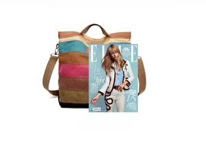 Detail view of colorful striped canvas tote with adjustable strap next to a magazine