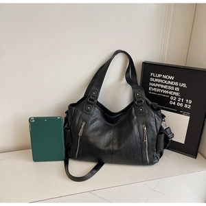 Detail of black large capacity PU leather tote bag with silver zippers for daily commute