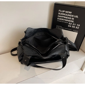 Top-down view of a black tote bag showing three zipper compartments and spacious interior