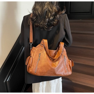 Brown vintage leather tote bag with functional zipper pockets and adjustable shoulder strap
