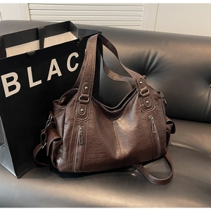 Detailed view of dark brown PU leather tote with textured finish and vertical zippers
