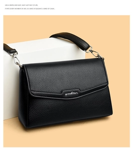 Close-up of black leather shoulder bag with lychee texture and wave flap design