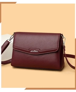 Close-up of wine red lychee pattern leather flap bag with elegant metal brand logo