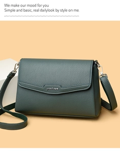 Close-up of dark green litchi grain leather shoulder bag with silver metal logo and flap