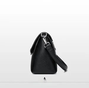 Side view detail of black litchi textured leather shoulder bag with silver hardware