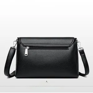 Detail view of back side of black lychee grain leather crossbody bag with silver zipper pocket