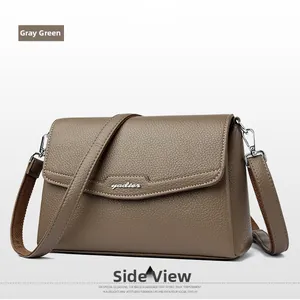 Detail view of a sage green pebbled leather flap crossbody bag with silver metal hardware