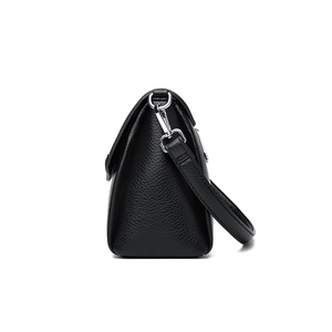 Sleek black lychee leather women's shoulder bag with silver hardware on white background