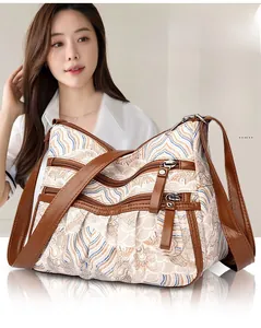 Detail of retro wave pattern fabric tote bag with brown leather trim and multi-zipper design