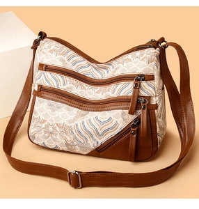 Detail of retro wave pattern fabric and multi-zipper compartments on a beige tote bag
