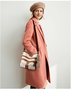 Detail of vintage pattern crossbody bag featuring multiple zipper pockets and leather trim