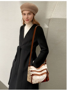 Detail showing multi-layer zipper pockets and adjustable strap on wave print crossbody bag