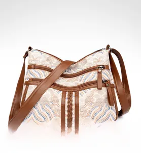 Detail view of vintage multi-pocket crossbody bag with embroidery and leather trim