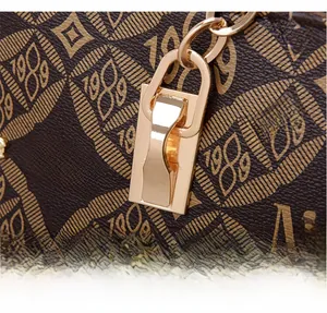 Gros plan du sac cabas en similicuir marron avec motif MC et boucles dorées