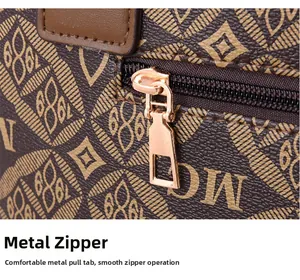 Détail du cuir à motif monogramme et de la fermeture éclair dorée lisse du sac fourre-tout
