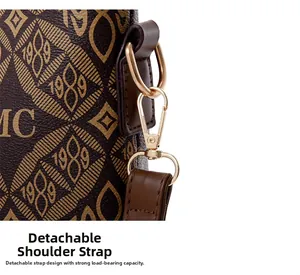 Détail du crochet doré et de la bandoulière en cuir à monogramme de ce sac vintage