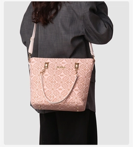 Détail d'un sac cabas rose clair avec imprimé monogramme et finitions métalliques