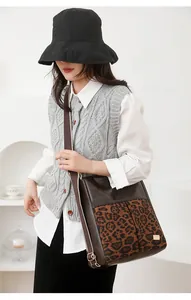 Detail of leopard print panel on dark brown PU leather crossbody bag with gold hardware