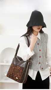Detail view of retro leopard print crossbody bag styled with a grey knitted vest
