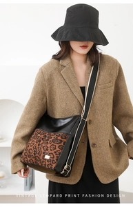 Detail of vintage leopard print crossbody bag with gold buckle on wool blazer