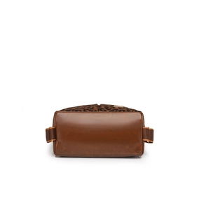 Close-up of leopard print stitching and polished brown leather texture on a travel handbag