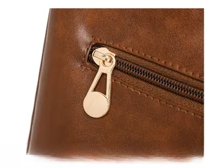 Macro detail of dark brown oil wax leather texture and premium gold metal zipper puller