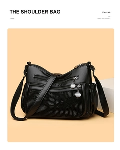 Détail d'un sac bandoulière noir orné de strass et doté de plusieurs compartiments zippés