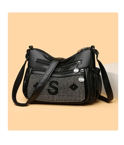 Détail du sac bandoulière noir en cuir avec double fermeture éclair et strass argentés brillants
