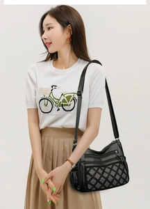 Détail du sac bandoulière noir avec motif de strass argentés et design à fermetures multiples