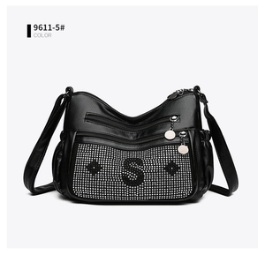 Détail du sac à bandoulière en cuir noir avec motif S et étoiles en strass brillants