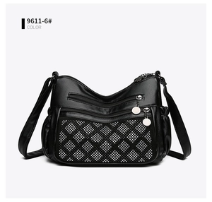 Détail d'un sac bandoulière en cuir noir avec paillettes argentées et plusieurs fermetures