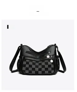 Vue de face du sac en cuir noir avec motif en damier de strass et fermetures éclair