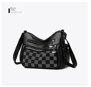 Vue détaillée du sac bandoulière noir avec motif à carreaux en strass et fermetures éclair