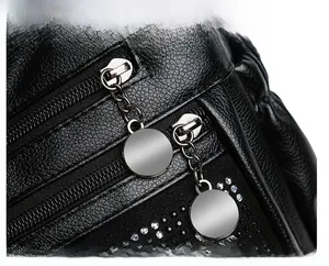 Gros plan sur les fermetures éclair doubles et les détails en strass sur sac en cuir noir
