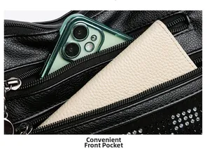 Détail de la poche zippée avant du sac noir avec téléphone et portefeuille à l'intérieur
