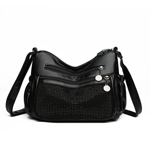Sac bandoulière en cuir noir avec multiples poches zippées et détails de rivets