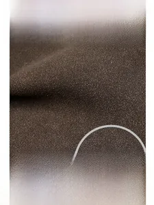 Detail of OUZUNO embossed logo on dark brown frosted texture large messenger bag